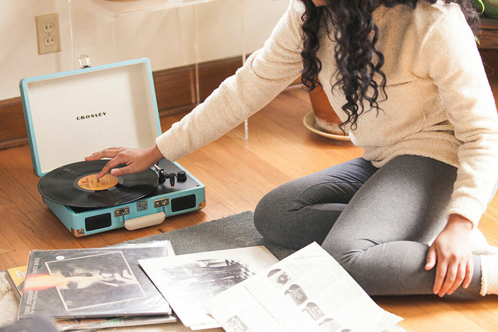 a woman putting a record on a record player