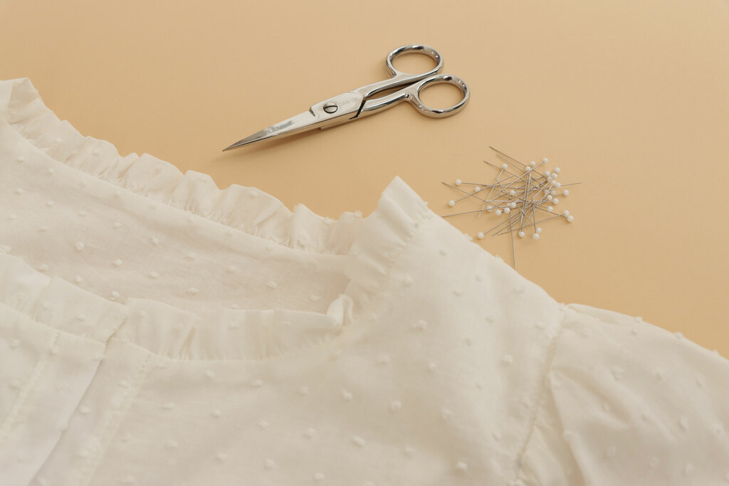 A blouse with scissors and pins next to it